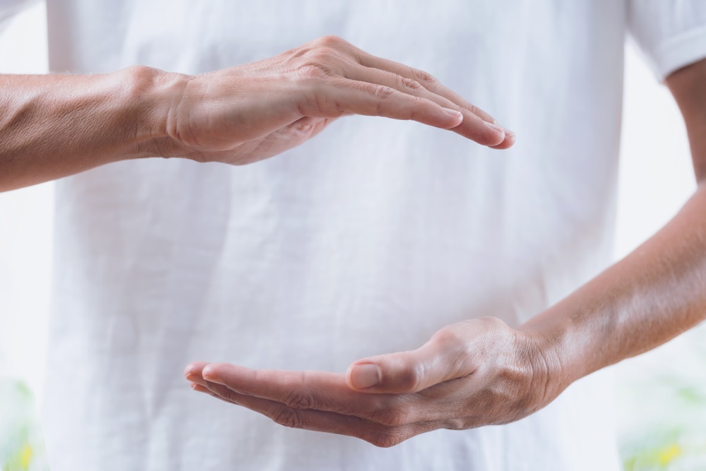 Person meditating in a serene environment for long distance Reiki preparation