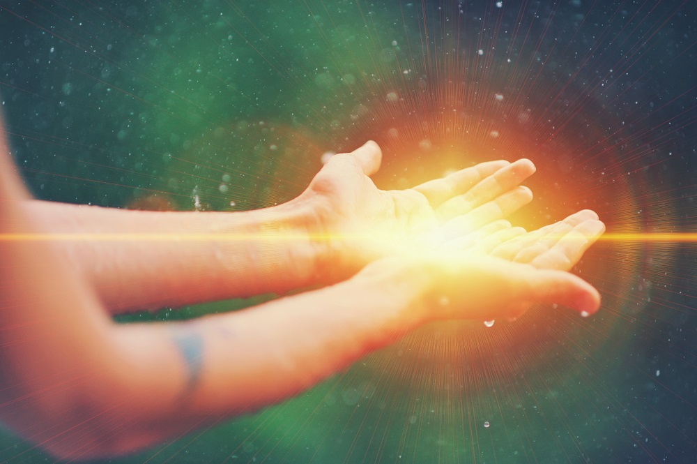 A pair of hands in a calming Reiki hand position, demonstrating techniques for anxiety relief.