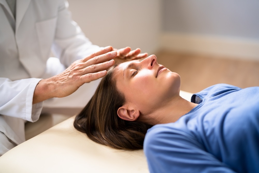 A pair of hands in a calming Reiki hand position, demonstrating techniques for anxiety relief.