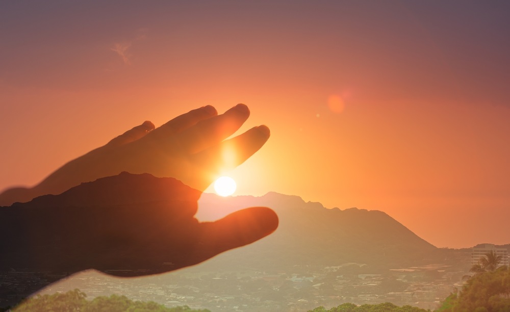 Person practicing energy healing exercises with radiant energy flow in a peaceful environment.