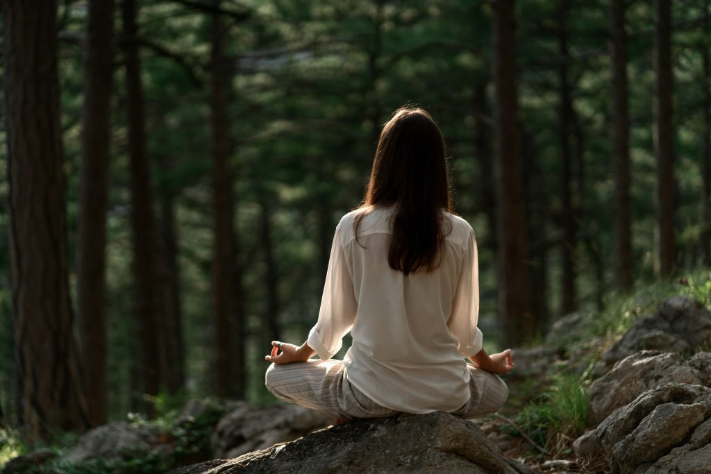 Person practicing meditation in a calm environment to reduce stress and reconnect with inner peace