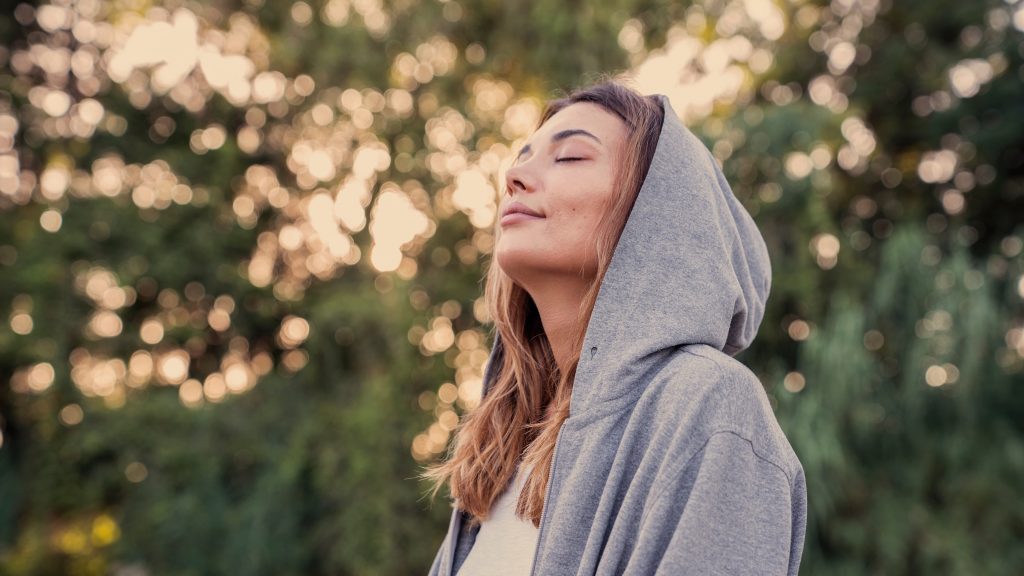 Woman practicing deep breathing exercises with eyes closed to promote relaxation before bed